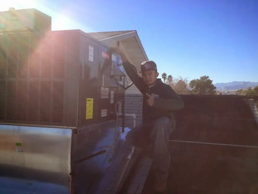 HVAC technician performing Heat Pump Repair on a rooftop unit in Arnold